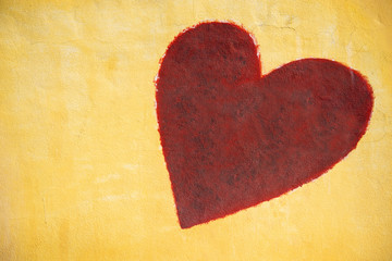 red heart painting on cement wall background.