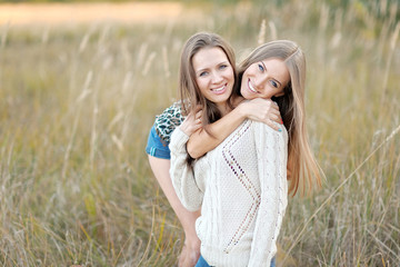 portrait of two beautiful sisters in the autumn