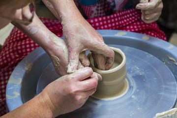 master potter holds a lesson for modeling on a potter's wheel