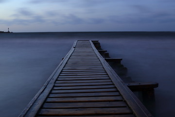 Pier into the sea at night