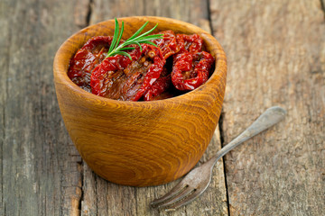 sun dried tomatoes with olive oil on wooden surface