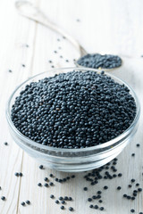 black lentils on table in bowl