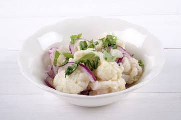 cauliflower salad in a white bowl