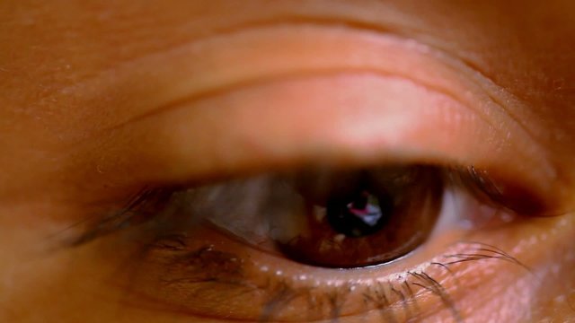 Female brown eye opens and wonders frightened. Macro video