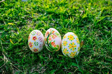 Three decorated easter eggs in the grass
