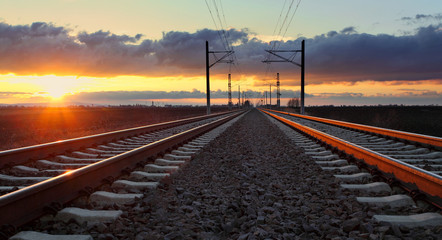 Naklejka na ściany i meble Railroad at sunset with sun and lines