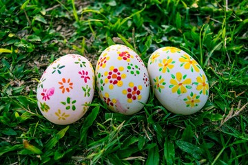 Three decorated easter eggs in the grass