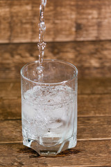 splash in water from a glass with ice, is isolated on a brown