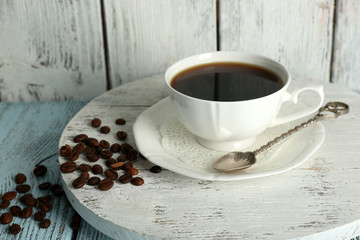 Cup of coffee with beans on color rustic wooden background