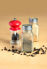 Pepper, pepper mill and spice jars on kitchen desk closeup