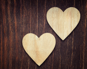 Two wooden hearts placed nicely on a vintage wood background