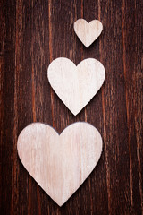 Various sized wooden hearts placed nicely on a vintage wood back