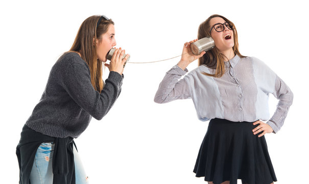 Twin sisters talking through tin phone