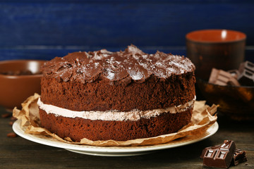Delicious chocolate cake on table on blue background