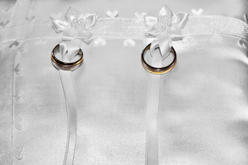 Wedding rings tied to pillow ring