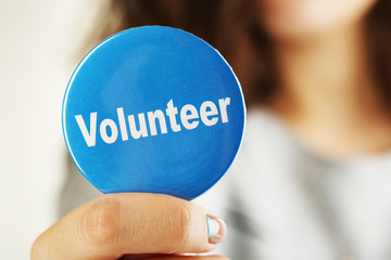 Round volunteer button in hand close-up