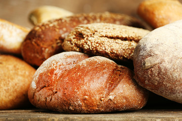 Different fresh bread on old wooden table