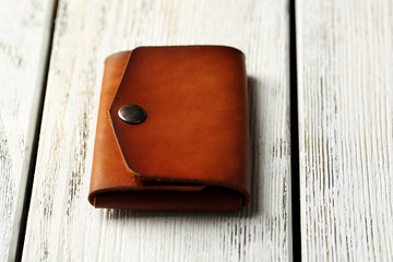 Hand made leather man wallet on white wooden background