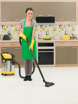 Woman Vacuuming Kitchen Floor