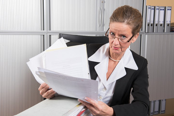 Chefin mit großem Papierstapel