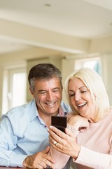 Happy mature couple looking at smartphone together