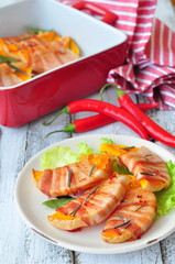 the pieces of pumpkin are baked in a bacon with rosemary