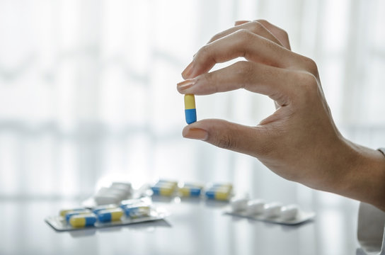 Woman hand holding a pill
