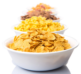Mix variety of breakfast cereal in white bowls 