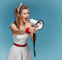 Angry pin-up girl shouting speaking trumpet