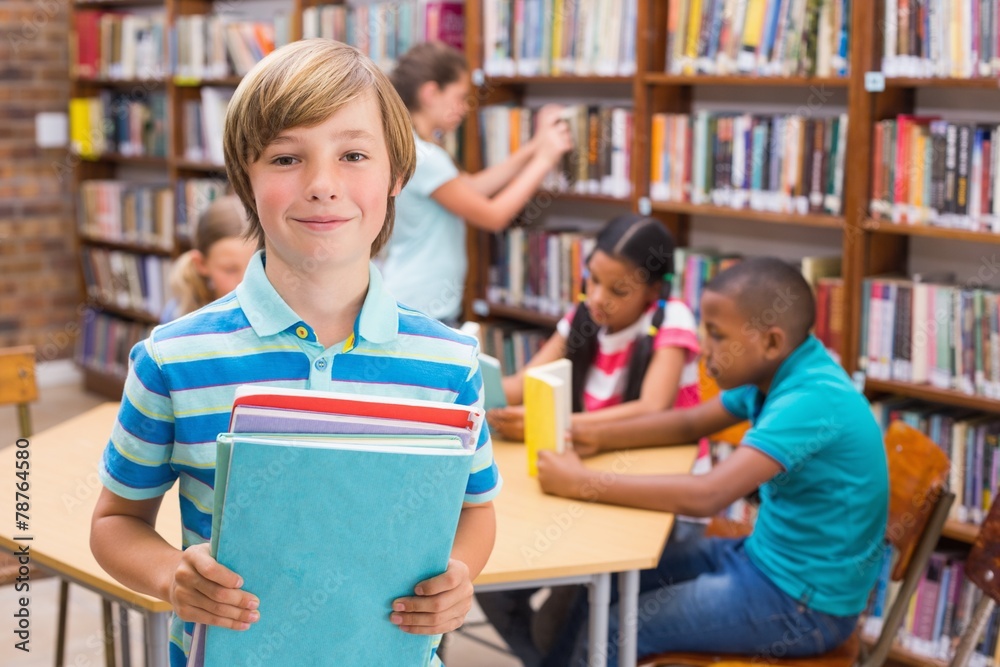 Canvas Prints Cute pupil smiling at camera in library