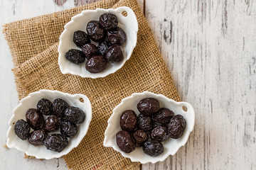Marinated Black Olives on White Wooden Baackground