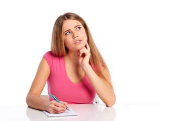 Young woman sitting behind the desk and thinking
