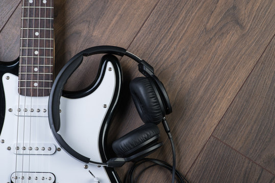Electric guitar with headphones on a brown wooden floor