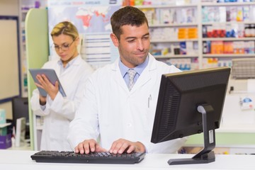 Smiling pharmacist using computer
