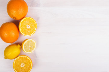 Fresh oranges and lemons on wooden background