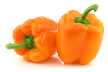 two fresh orange bell peppers on a white background