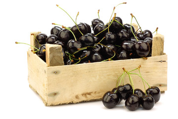 fresh delicious cherries in a wooden box on a white background