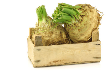 celery roots with some foliage in a wooden crate 