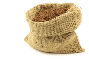 Flax seed (linseed) in a burlap bag on a white background