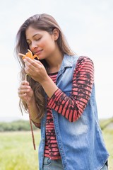 Fototapeta premium Pretty brunette smelling a flower