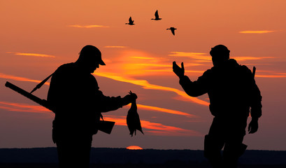 deux chasseurs au coucher du soleil