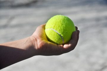 Tennis ball in his hand.