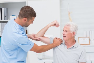 Fototapeta premium Physiotherapist giving massage to senior man