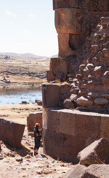 photographer standing near the tower of Sillustani, Lake Umayo,
