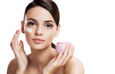 Beautiful young woman applying moisturizing creme