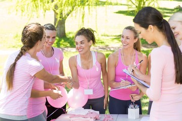 Smiling women organising event for breast cancer awareness