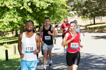 Happy people running race in park
