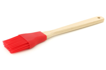 red silicon brush with wooden handle on a white background