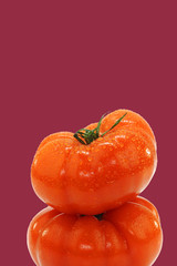 two stacked beef tomatoes on a purple background