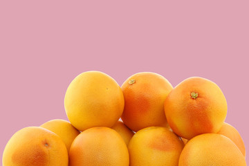 bunch of red grapefruits on a pink background